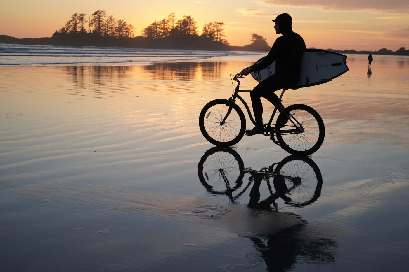 surfer on a belt drive cypre bikes beach cruiser at sunset